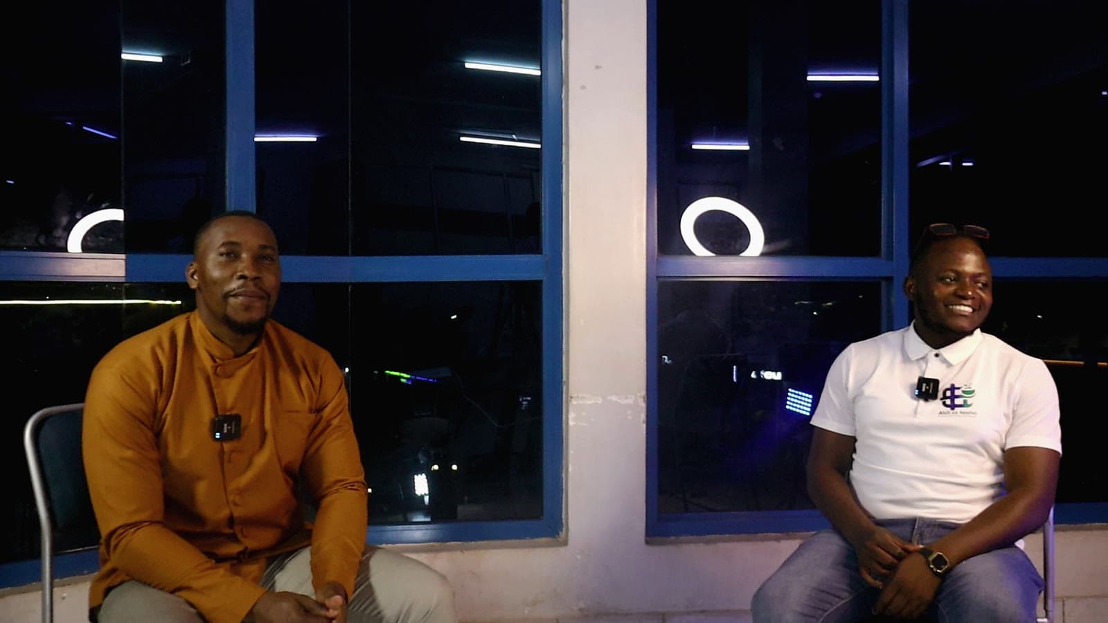 Wide shot of a night session on set, both people smiling